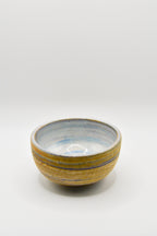 Small ceramic bowl with a striped design on a white background