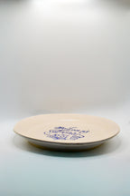 Round white plate with blue text 'Welcom my Friends 1661' on a white background