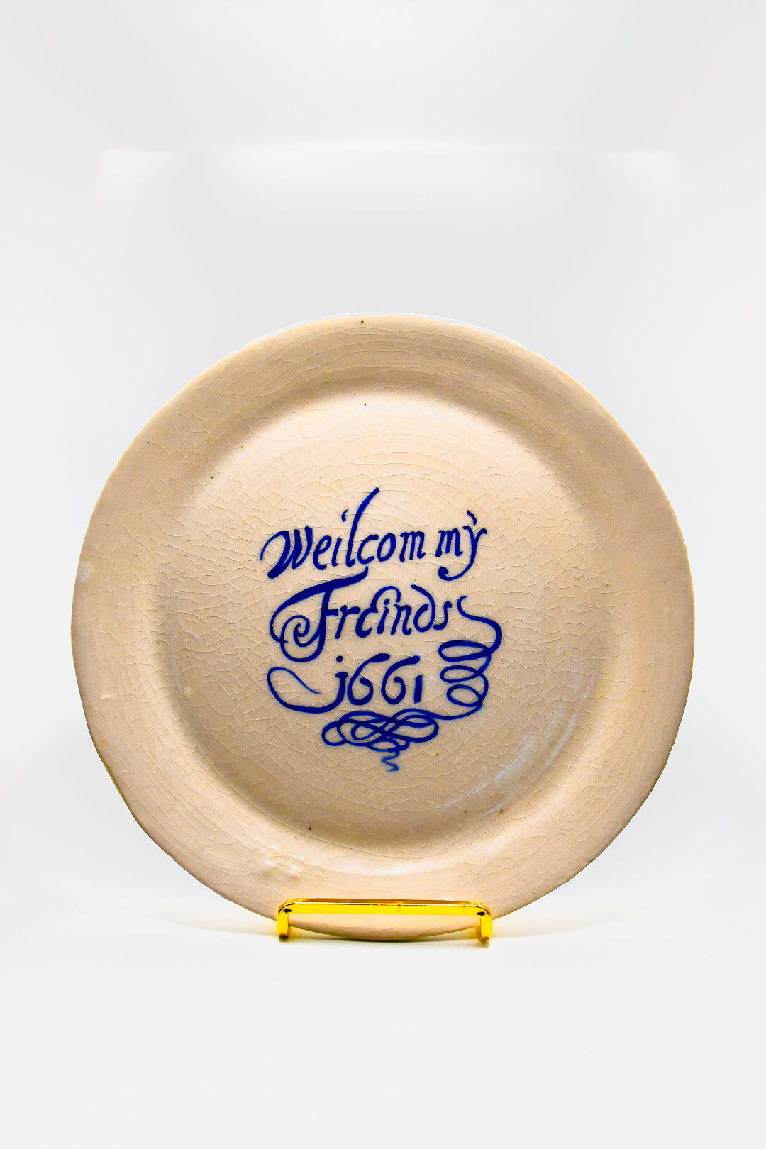 Round white plate with blue text 'Welcom my Friends 1661' on a white background