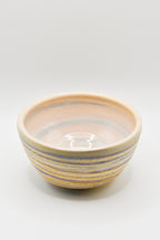 Ceramic bowl with blue and beige stripes on a white background