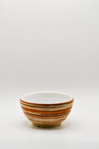 Ceramic bowl with brown stripes on a white background