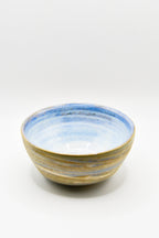 Ceramic bowl with blue and gold stripes on a white background