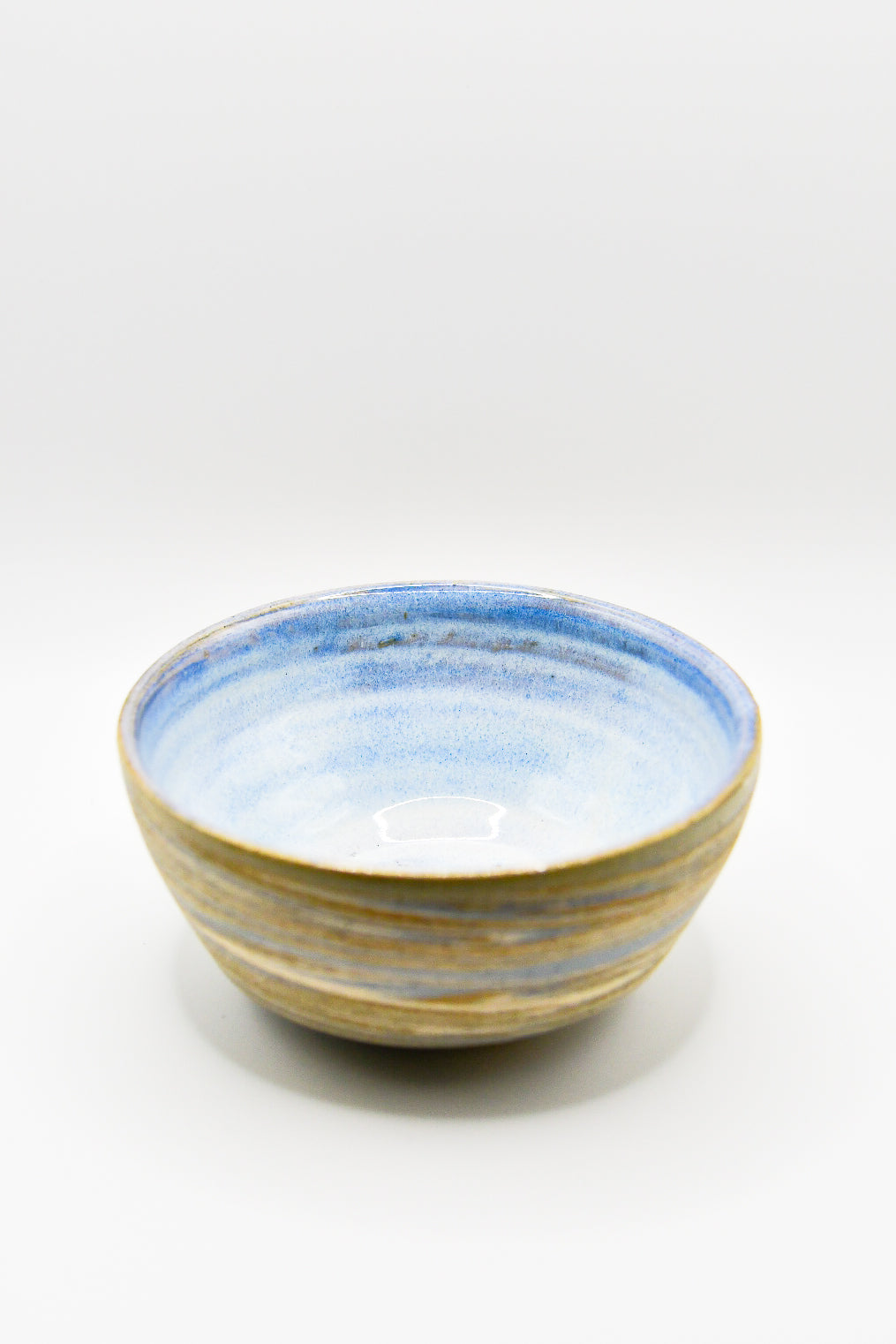 Ceramic bowl with blue and gold stripes on a white background