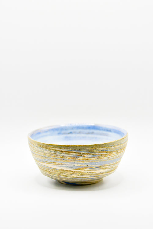 Ceramic bowl with blue and gold stripes on a white background