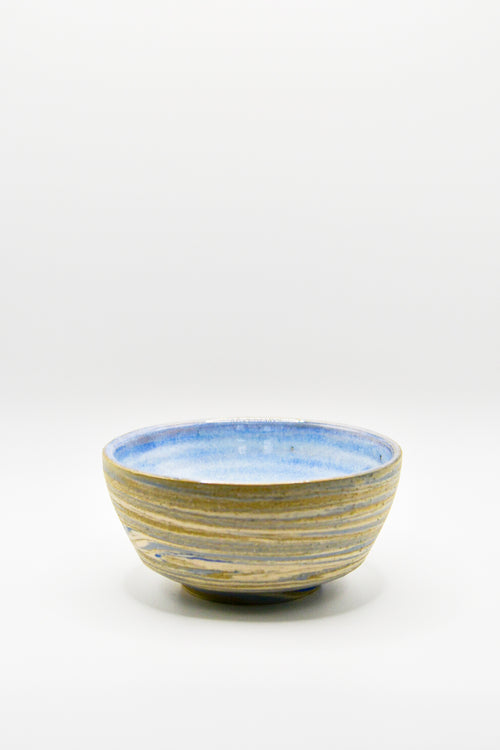 Ceramic bowl with blue and gold stripes on a white background