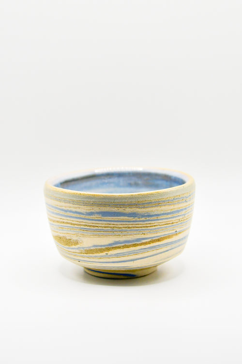 Ceramic bowl with blue and gold stripes on a white background