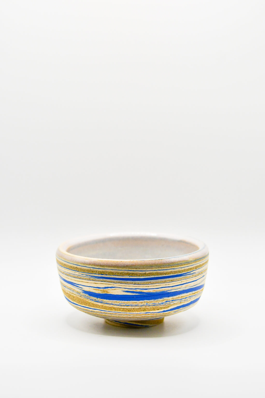 Ceramic bowl with blue and gold stripes on a white background