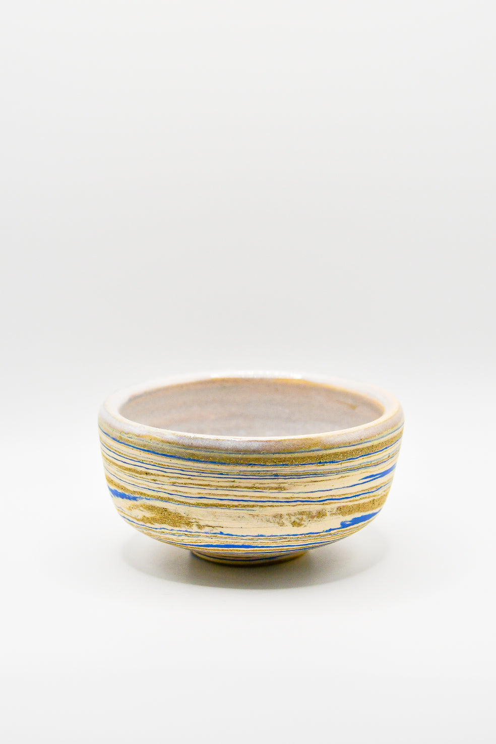 Ceramic bowl with blue and gold stripes on a white background