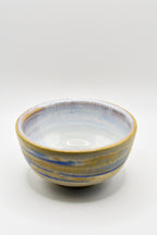 Ceramic bowl with blue and yellow stripes on a white background
