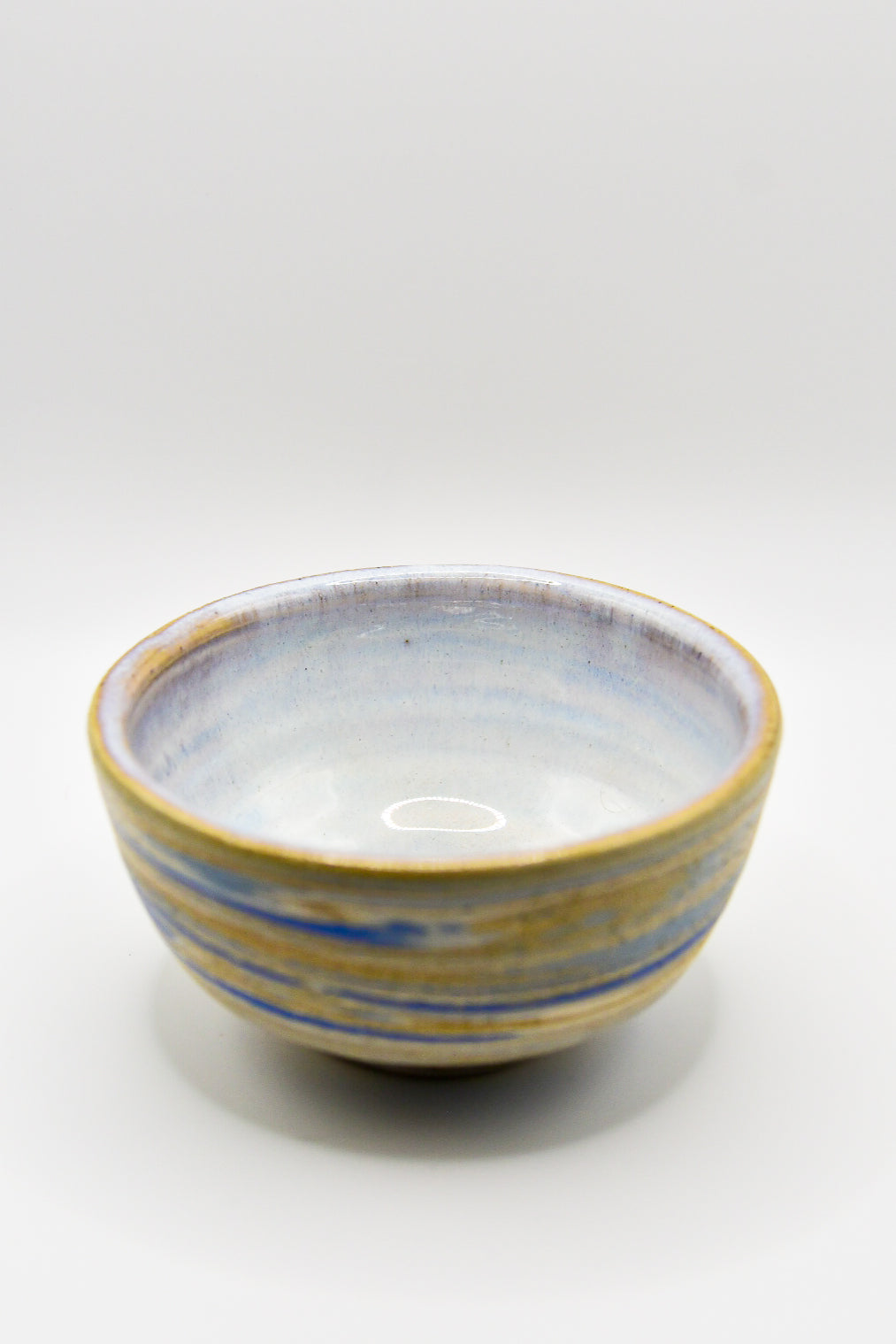 Ceramic bowl with blue and yellow stripes on a white background