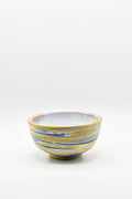 Ceramic bowl with blue and yellow stripes on a white background