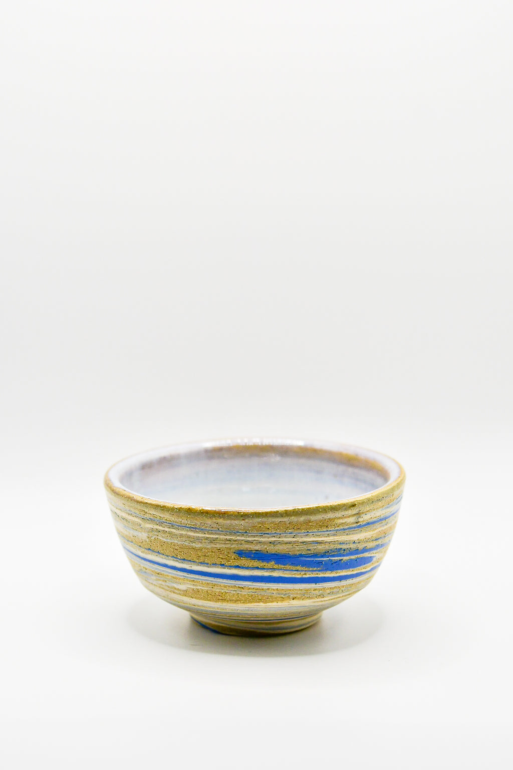 Ceramic bowl with blue and yellow stripes on a white background