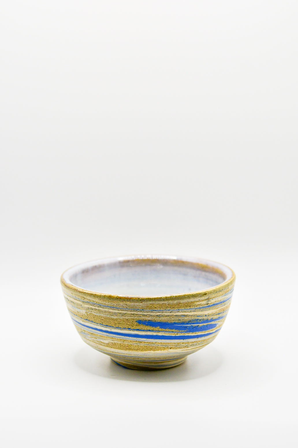 Ceramic bowl with blue and yellow stripes on a white background
