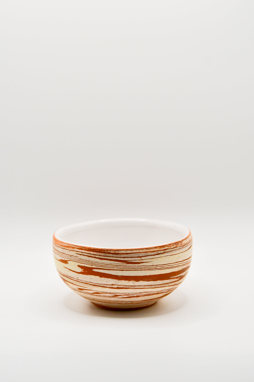 Ceramic bowl with striped pattern on a white background