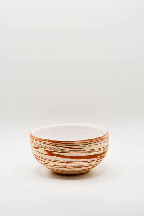 Ceramic bowl with striped pattern on a white background