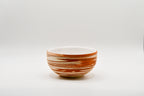 Ceramic bowl with brown and white stripes on a white background