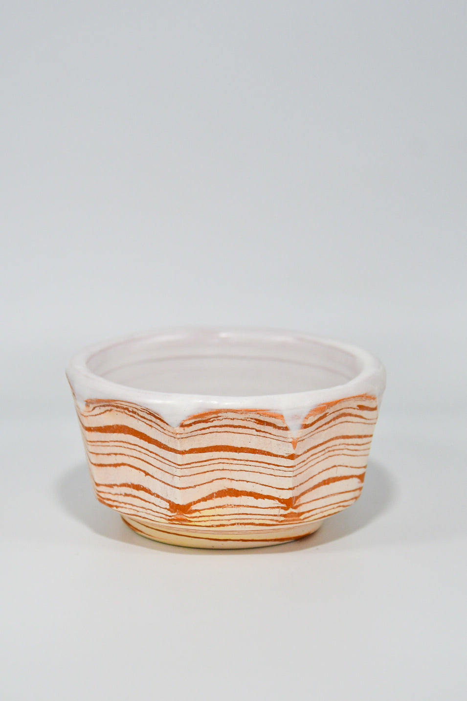 Ceramic bowl with wavy orange pattern on a white background