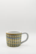 Ceramic mug with blue and beige pattern on a white background
