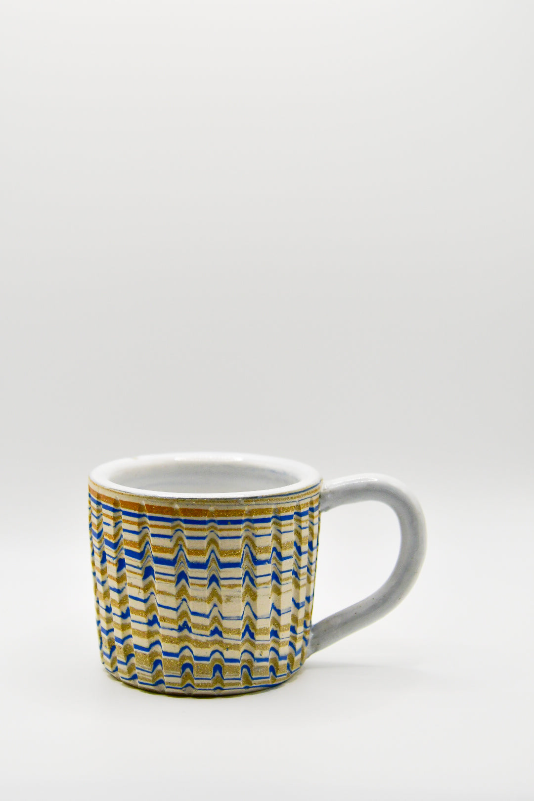Ceramic mug with blue and beige pattern on a white background