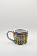 Ceramic mug with blue and beige pattern on a white background