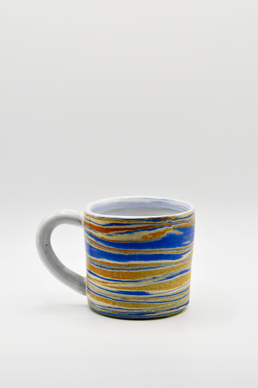 Ceramic mug with blue and orange striped pattern on a white background