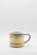 Ceramic mug with blue and beige pattern on a white background