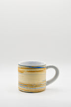 Ceramic mug with blue and beige pattern on a white background