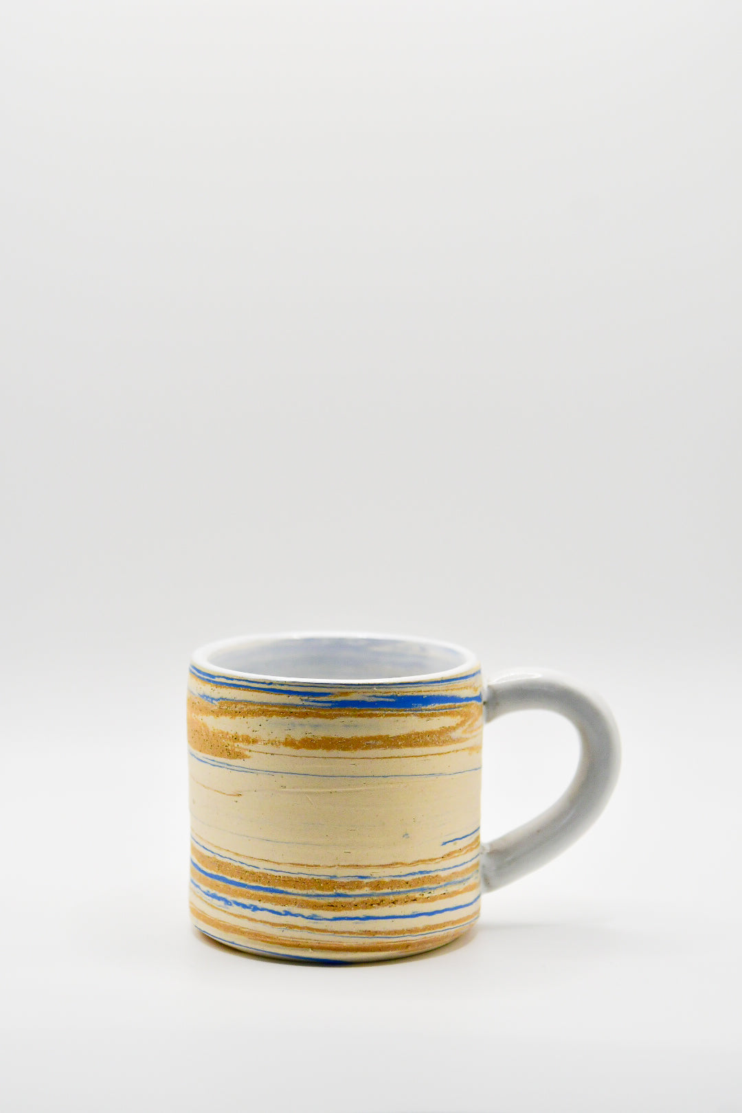 Ceramic mug with blue and beige pattern on a white background