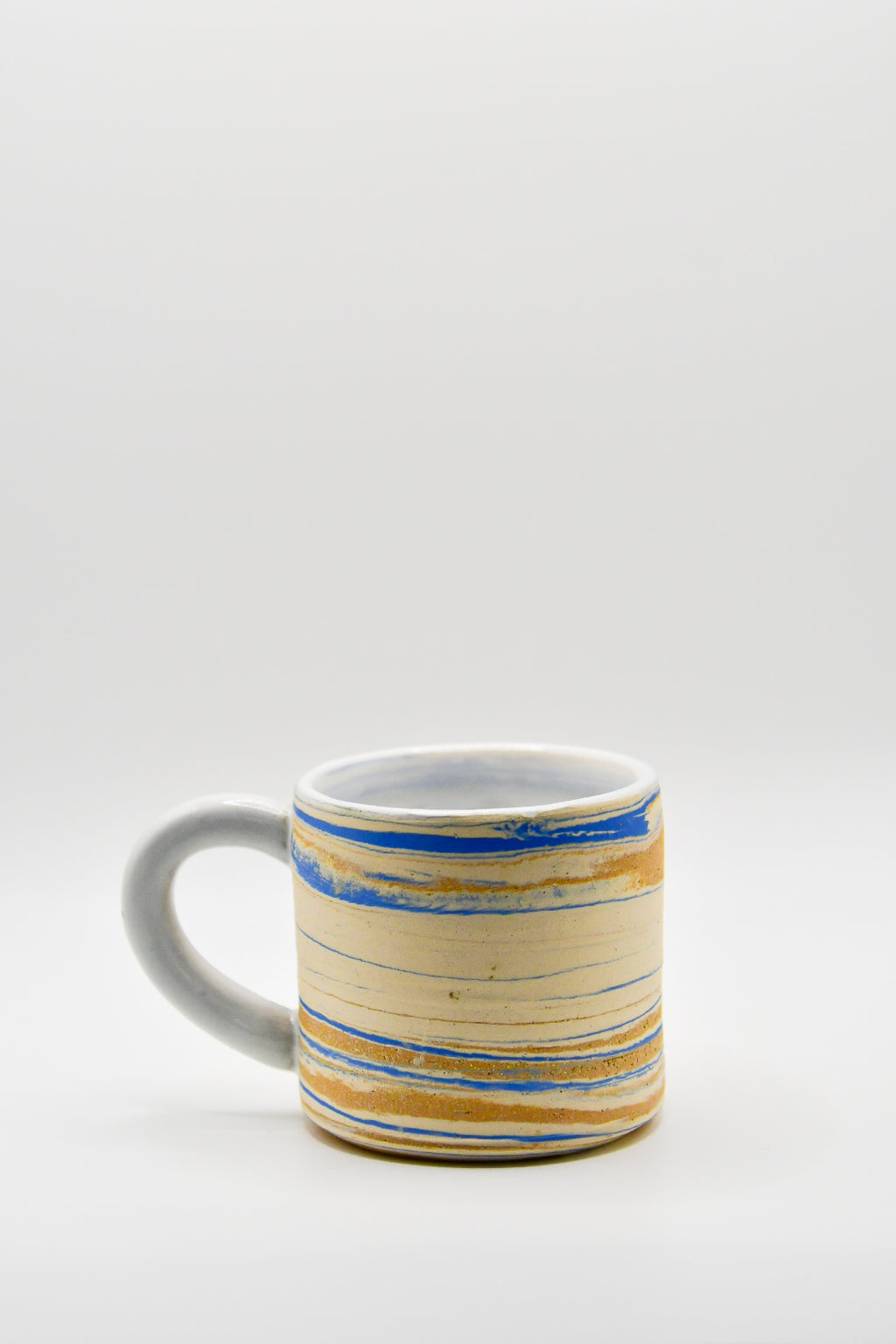 Ceramic mug with blue and beige pattern on a white background