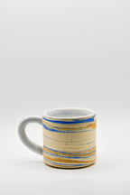Ceramic mug with blue and beige pattern on a white background