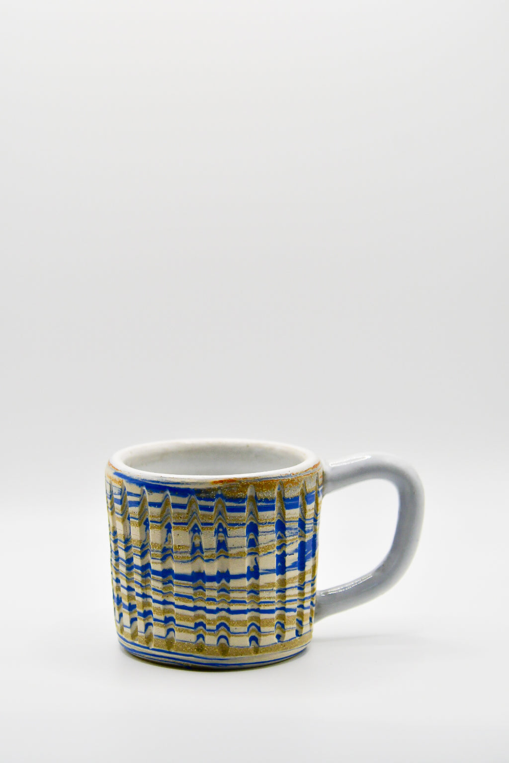 Ceramic mug with blue and beige pattern on a white background