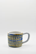 Ceramic mug with blue and beige pattern on a white background