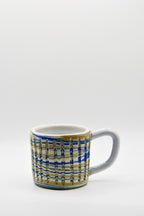 Ceramic mug with blue and beige pattern on a white background