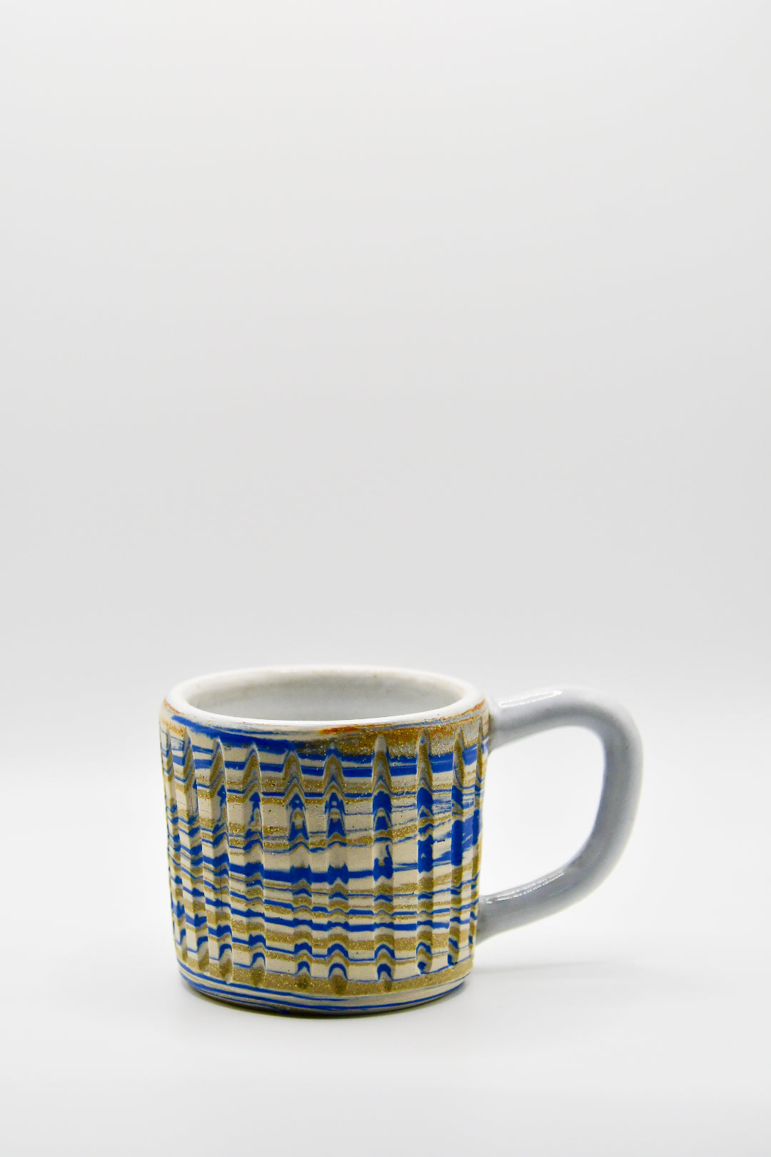 Ceramic mug with blue and beige pattern on a white background