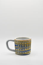 Ceramic mug with blue and beige pattern on a white background