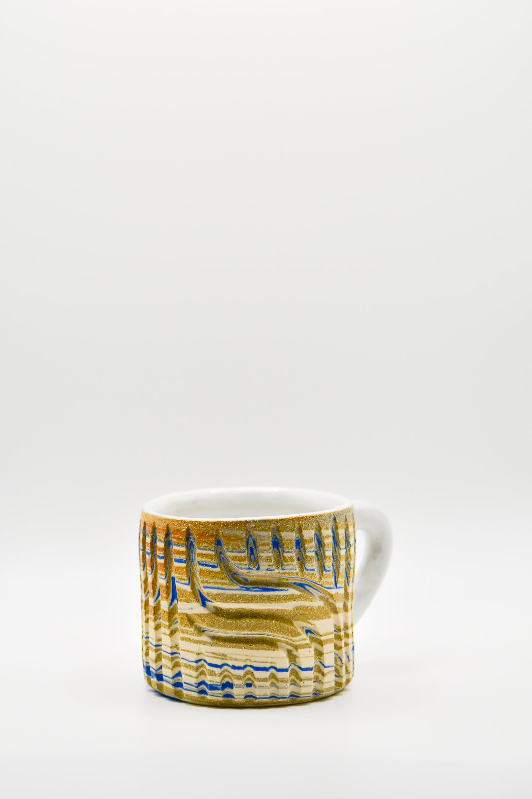 Ceramic mug with blue and beige pattern on a white background