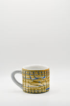 Ceramic mug with blue and beige pattern on a white background