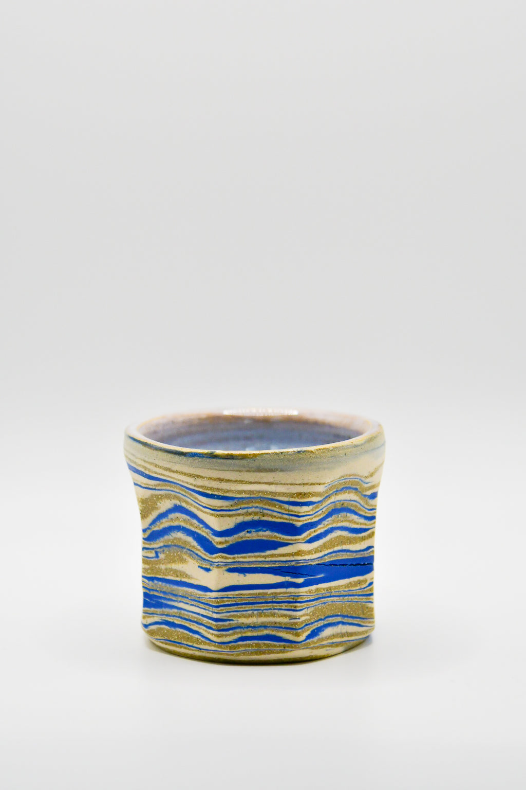 Ceramic mug with blue and beige pattern on a white background
