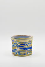 Ceramic mug with blue and beige pattern on a white background