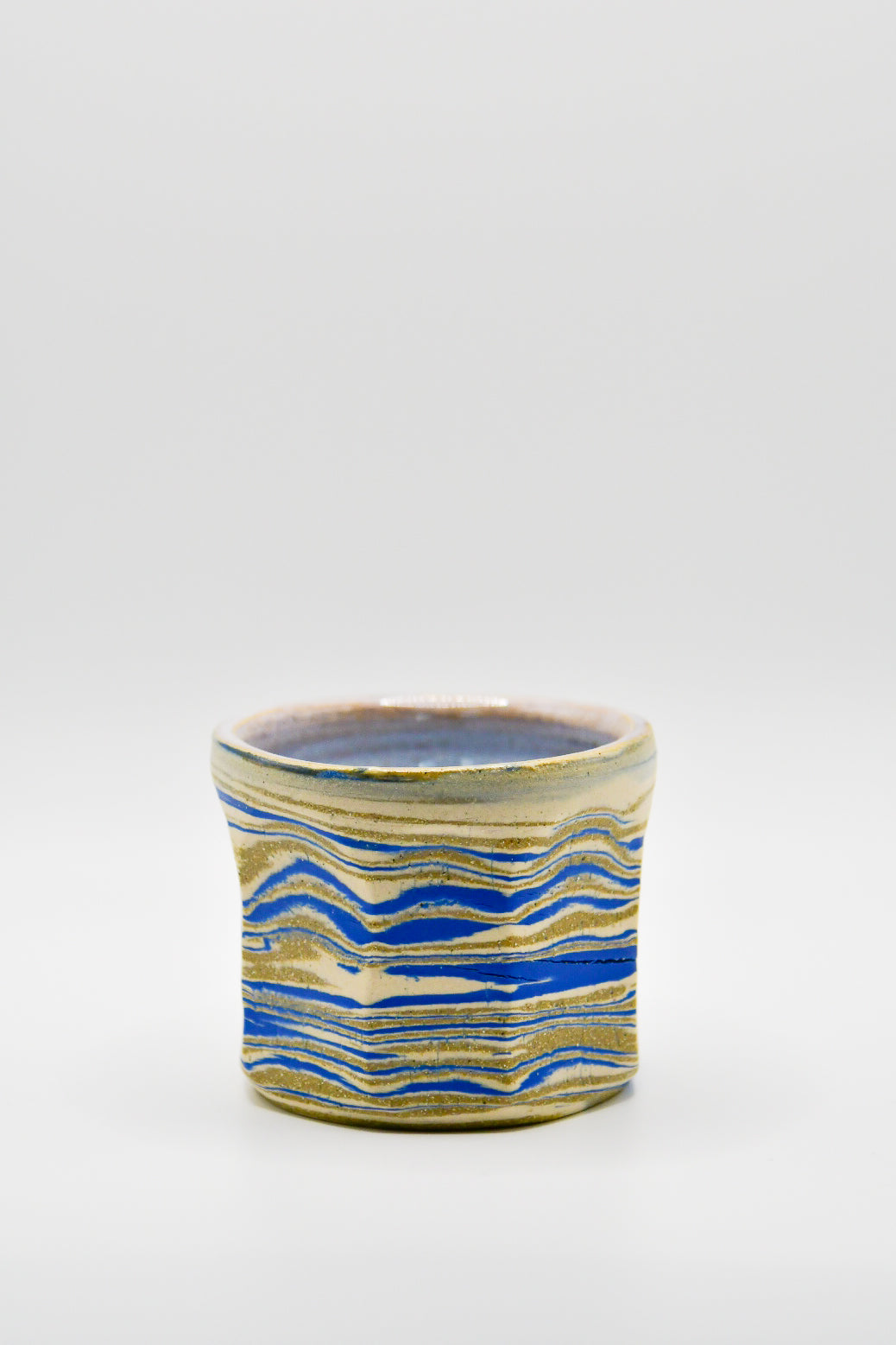 Ceramic mug with blue and beige pattern on a white background