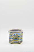 Ceramic cup with blue and beige pattern on a white background