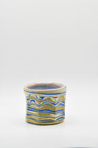 Ceramic cup with blue and beige pattern on a white background
