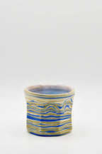 Ceramic cup with blue and beige pattern on a white background