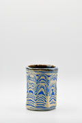 Ceramic cup with blue and beige pattern on a white background