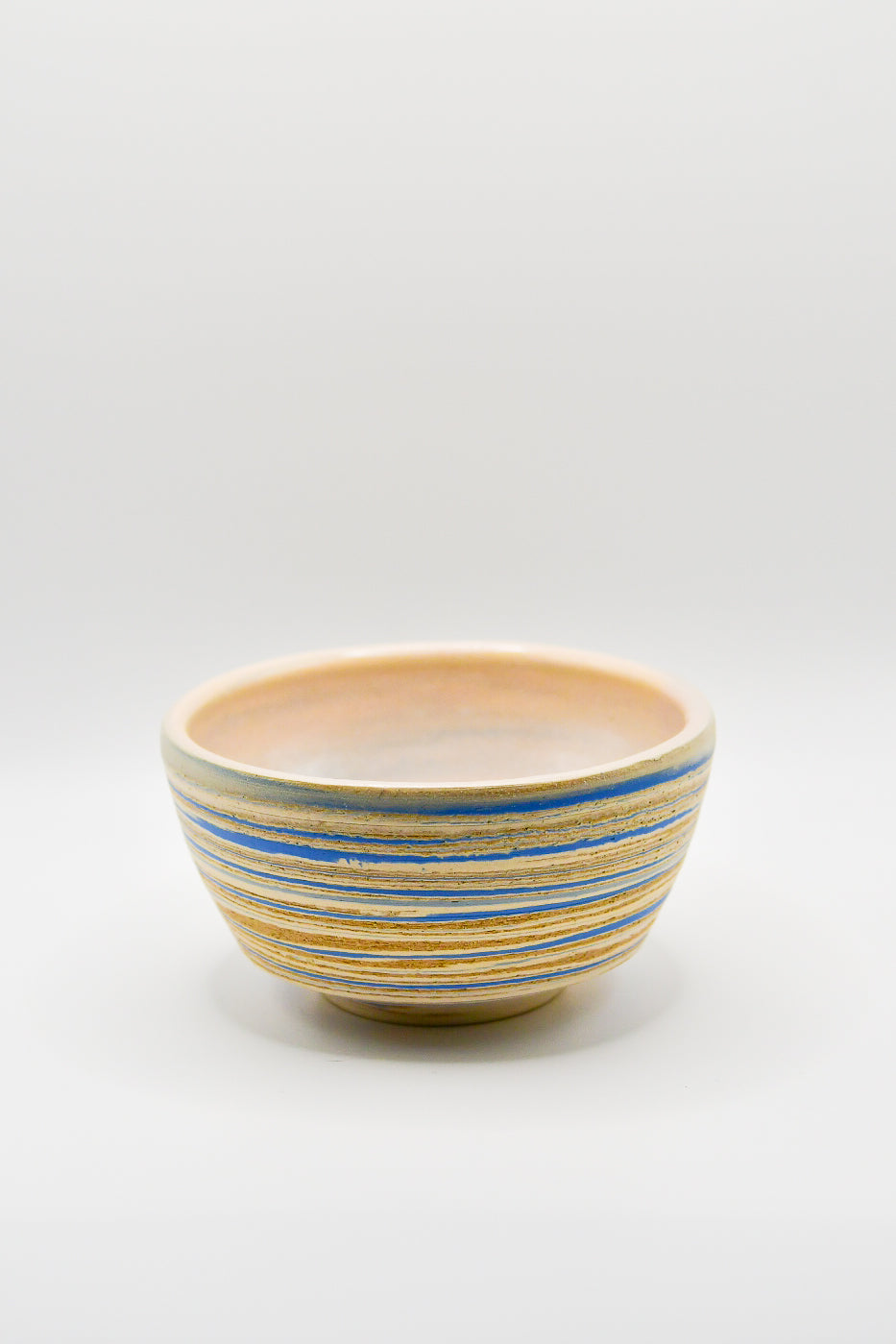 Ceramic bowl with blue and beige stripes on a white background