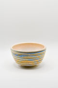 Ceramic bowl with blue and beige stripes on a white background
