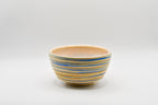 Ceramic bowl with blue and beige stripes on a white background